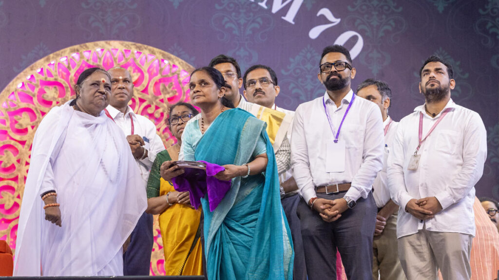 Amma stands with scientists as they inaugurate new device
