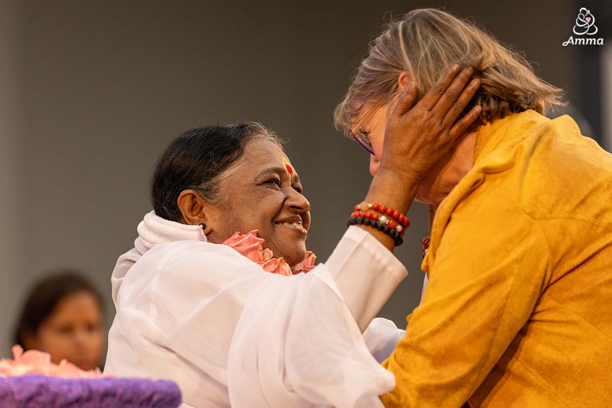 Amma embraces a woman
