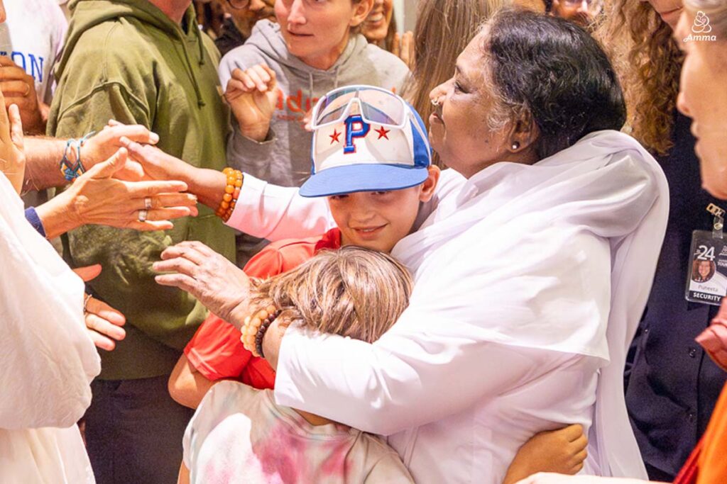 Amma embraces two children