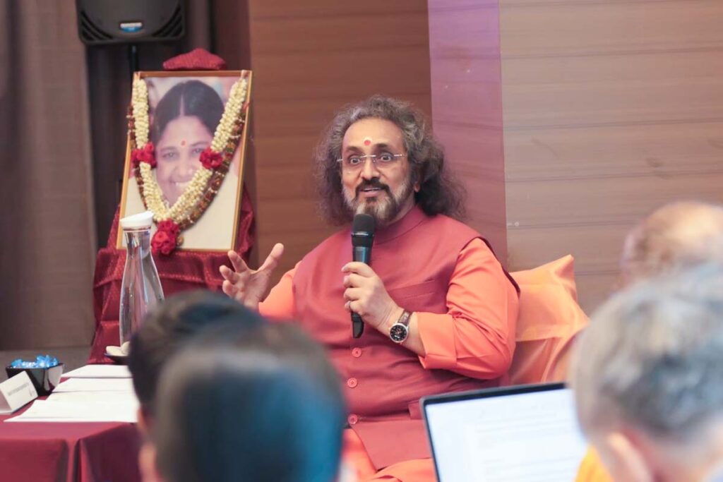Swamiji smiles with a microphone
