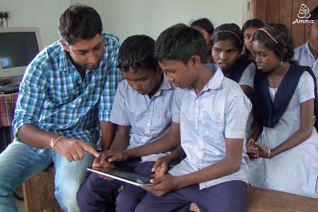 a young man teaches adolescent boys on a tablet