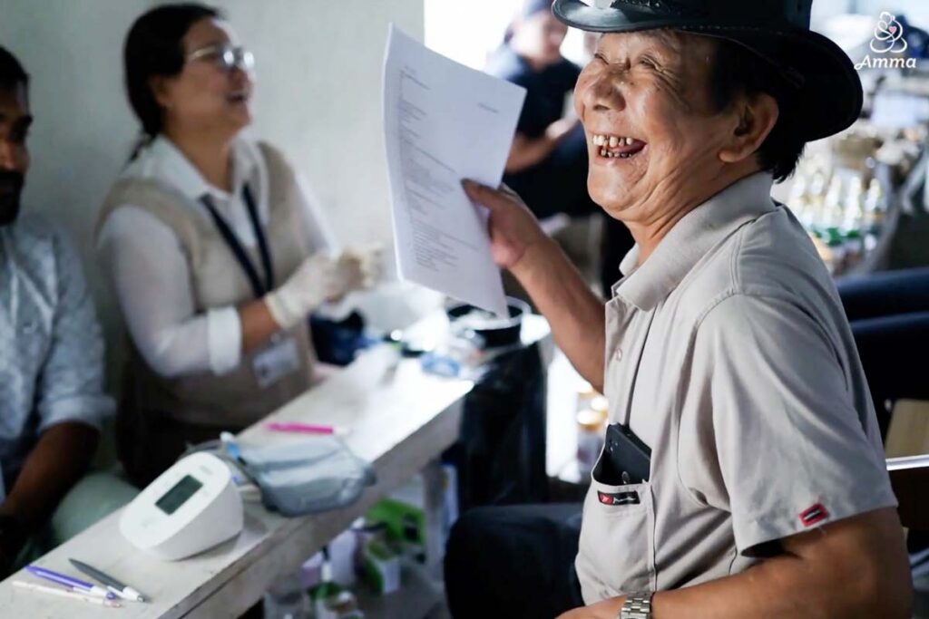 a man laughs as he holds the paper from his medical consultation