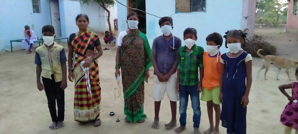 Villagers stand with mouths covered