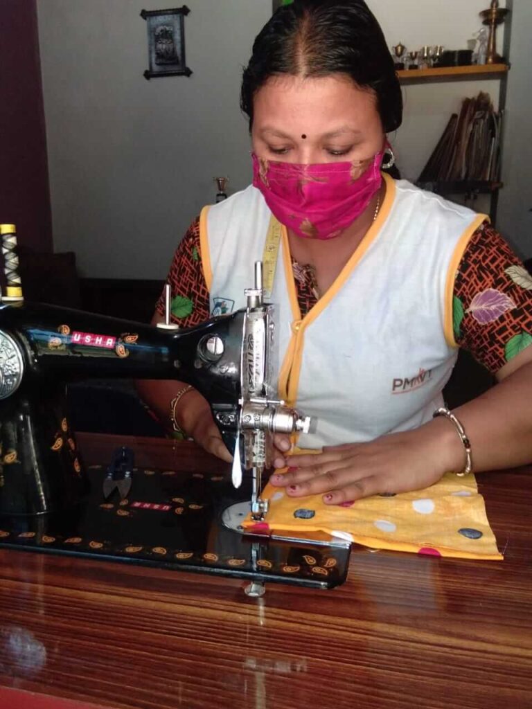 Woman sews colorful mask