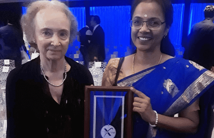 Two women holding the award plaque.