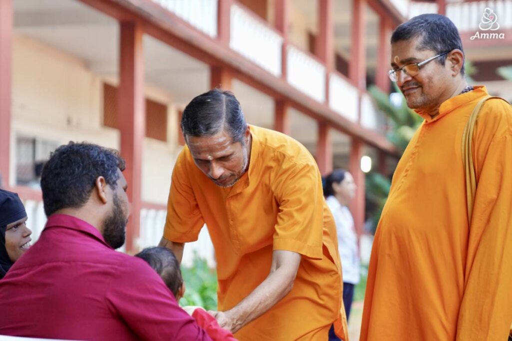 two brahmacharis with a father and child