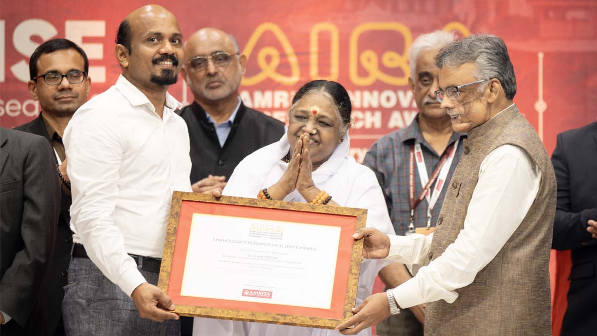 Amma presents an award to a faculty