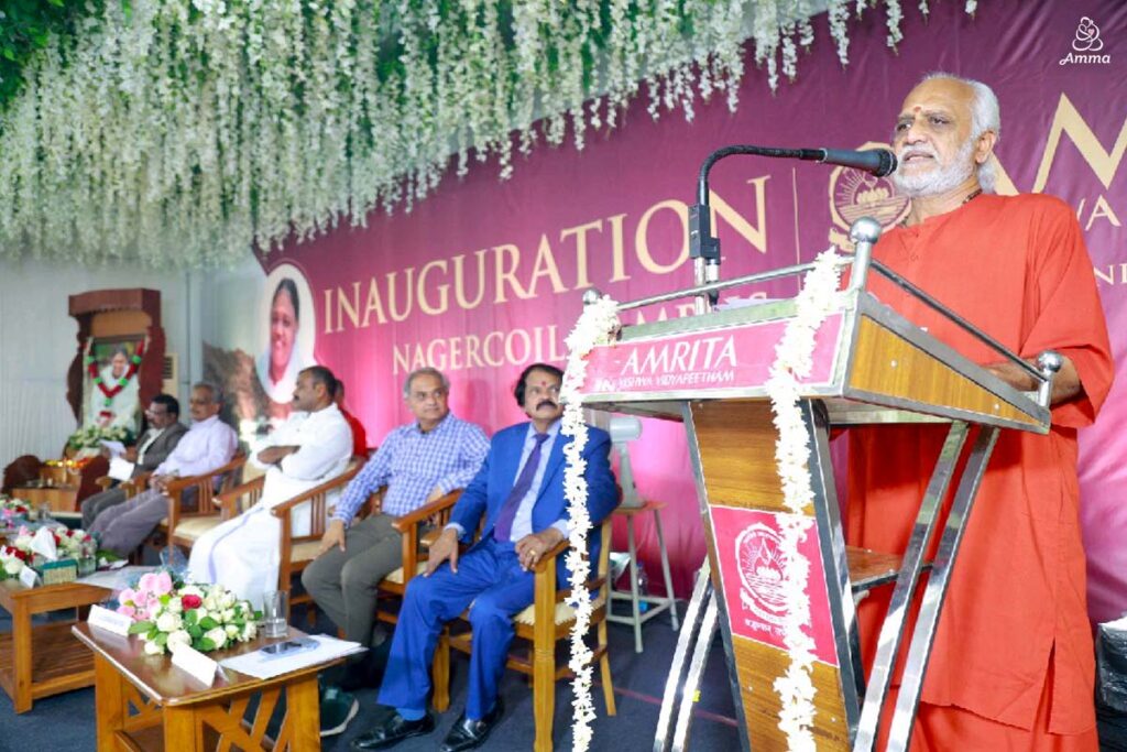 A Swami speaks at a microphone