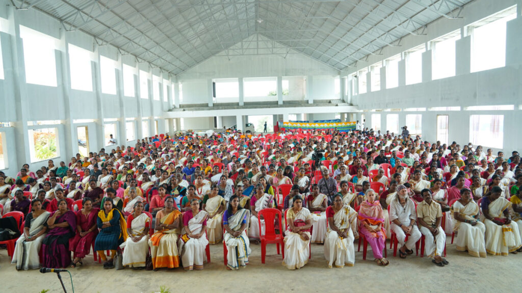 4000 women sitting listening to speakers before they receive their kits.