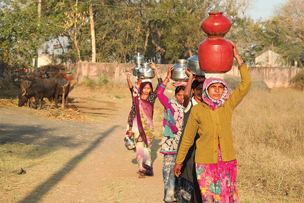 Women carry pots of water on their heads