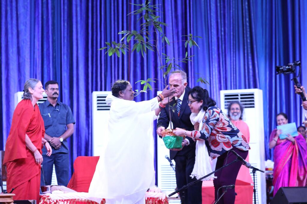 Amma reaches out to embrace a rudraksha tree