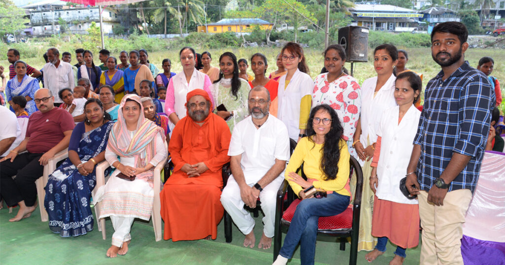 Swami Purnamritananda sits with local residents and volunteers