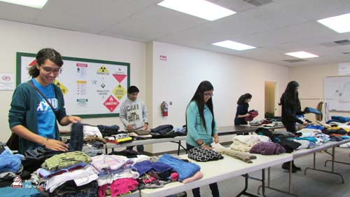 Volunteers sort clothing on tables