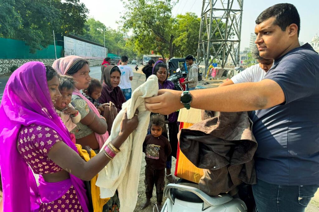A volunteer gives clothing to women and children