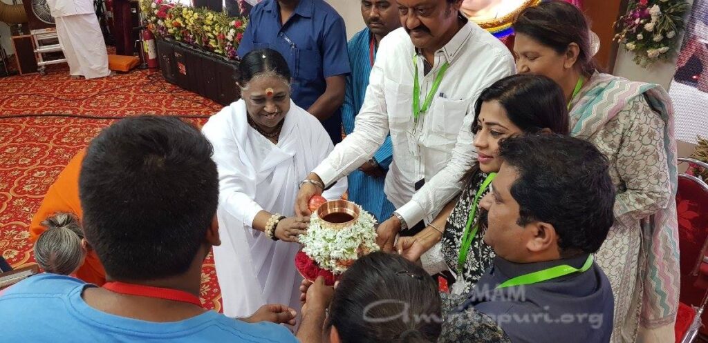 Amma and others holding the symbolic pitcher.