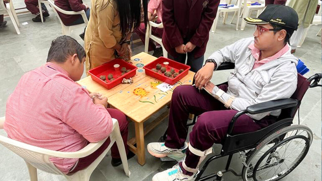 Student in wheelchair makes a seed ball