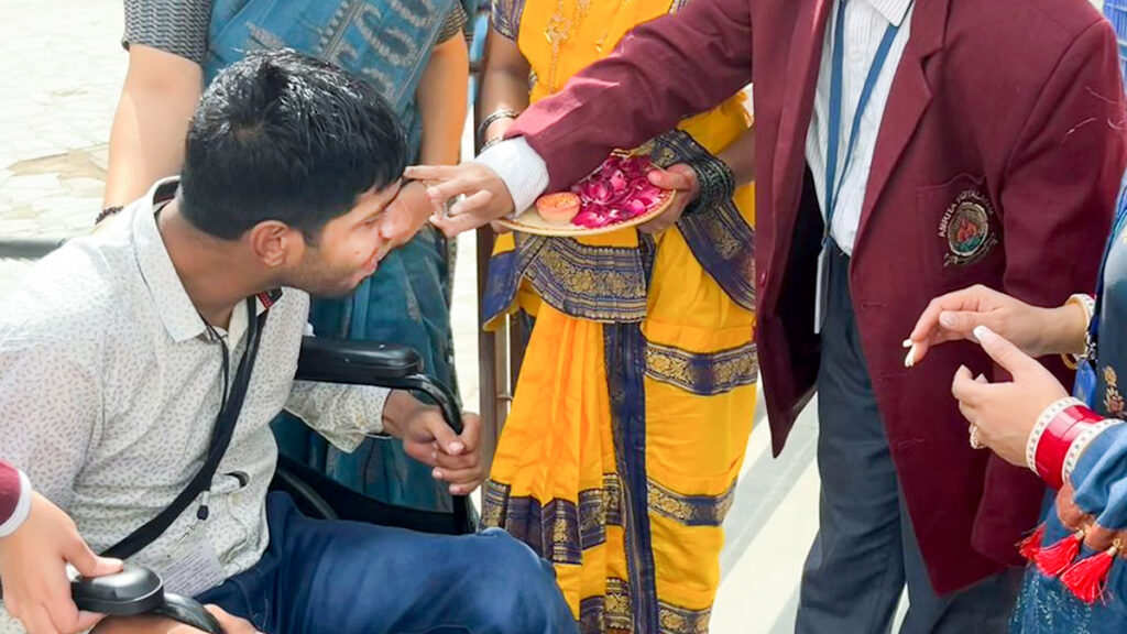 Student in wheelchair receives traditional welcome on his forehead