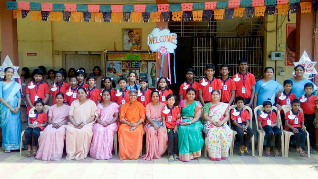 All students sit together with the presiding Swamini of the school