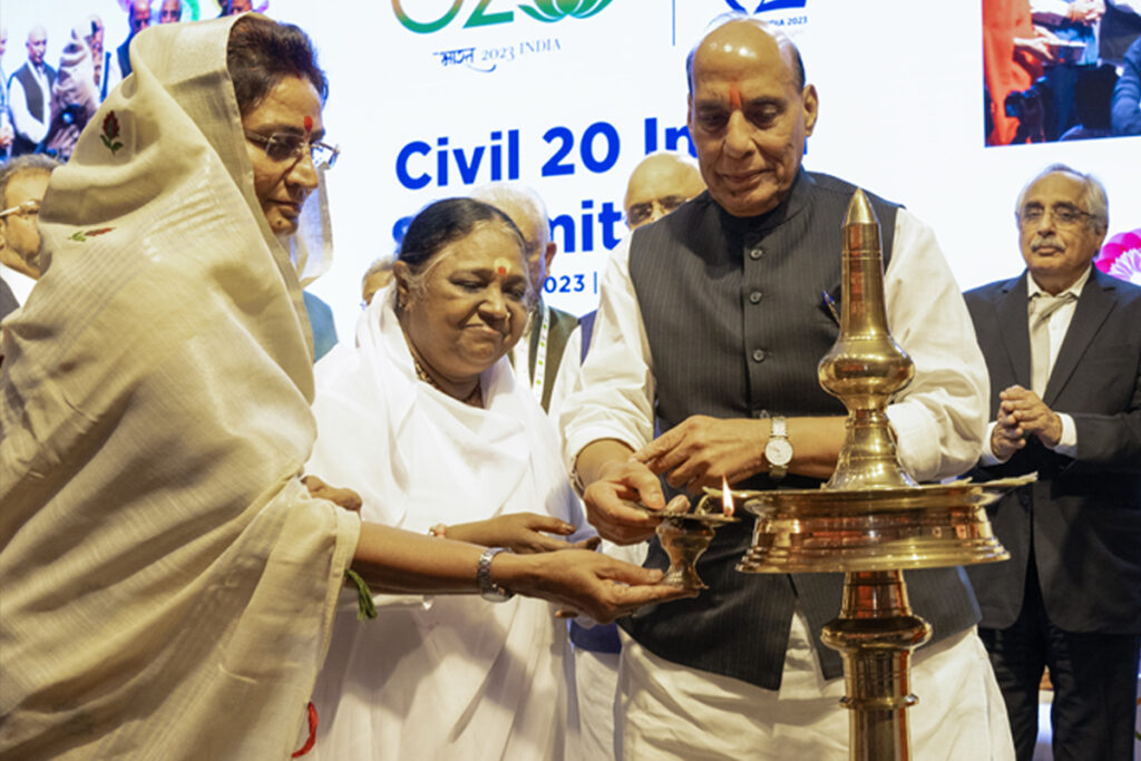 Smt. Shakuntala Rawat, Hon’ble Minister of Industry, State Enterprises & Devasthan, Govt. of Rajasthan; Amma; and Shri Rajnath Singh, Hon’ble Minister of Defence, Govt. of India, light the inaugural lamp.