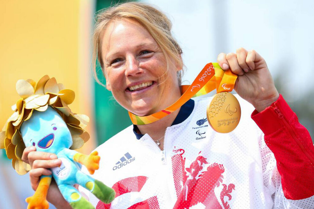 A woman holds a gold medal