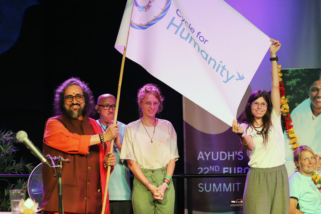 a swami and three youth wave a flag