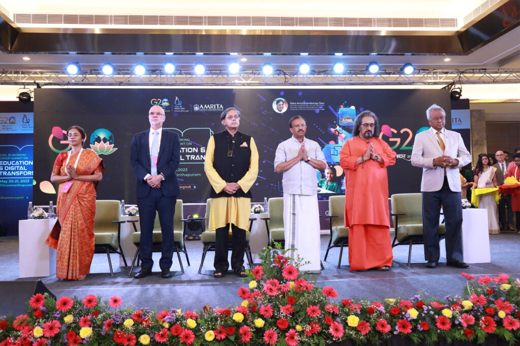 All the  dignitaries stand facing front to audience in pranam and graitude for the event. 