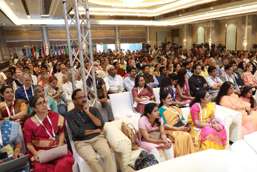 Hundreds of delegates seated in the audience  are enraptured by the speakers. 