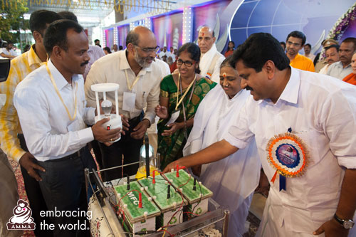 Amma and dignitaries look at the model built by scientists