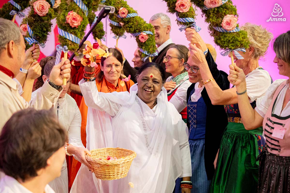 Amma walking through arches of leaves and flowers