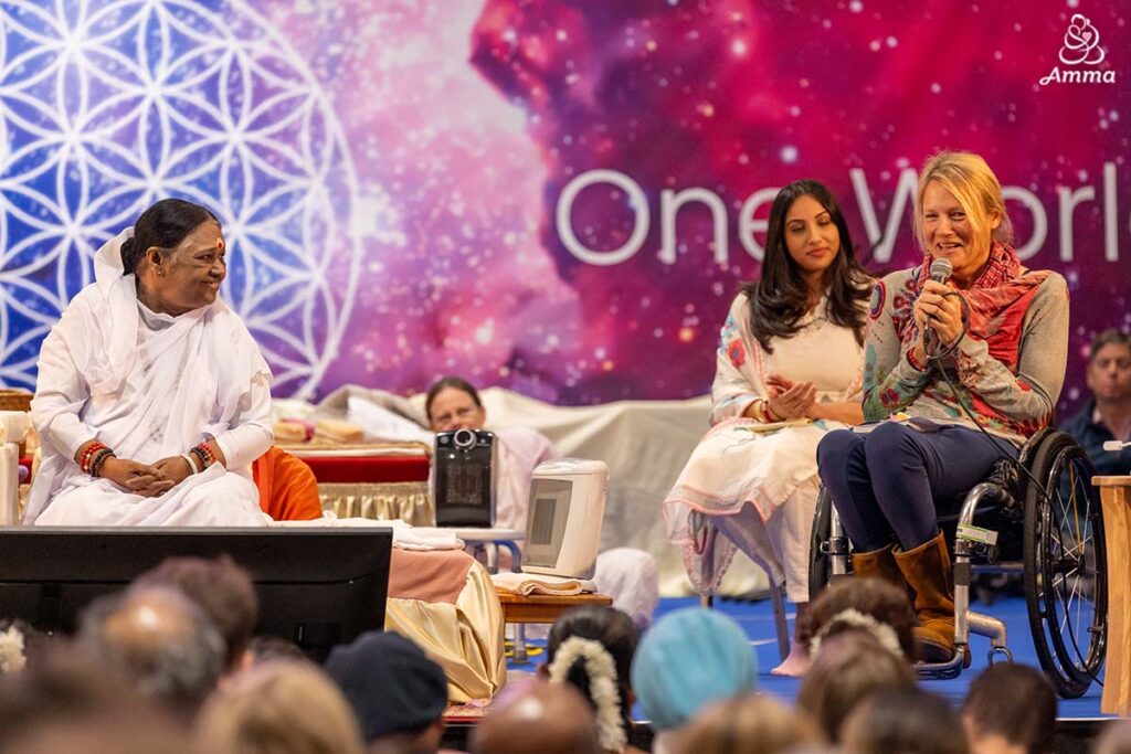 Amma looks at a woman speaking