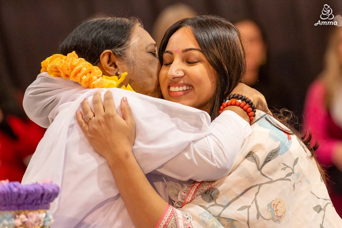Amma embraces a woman