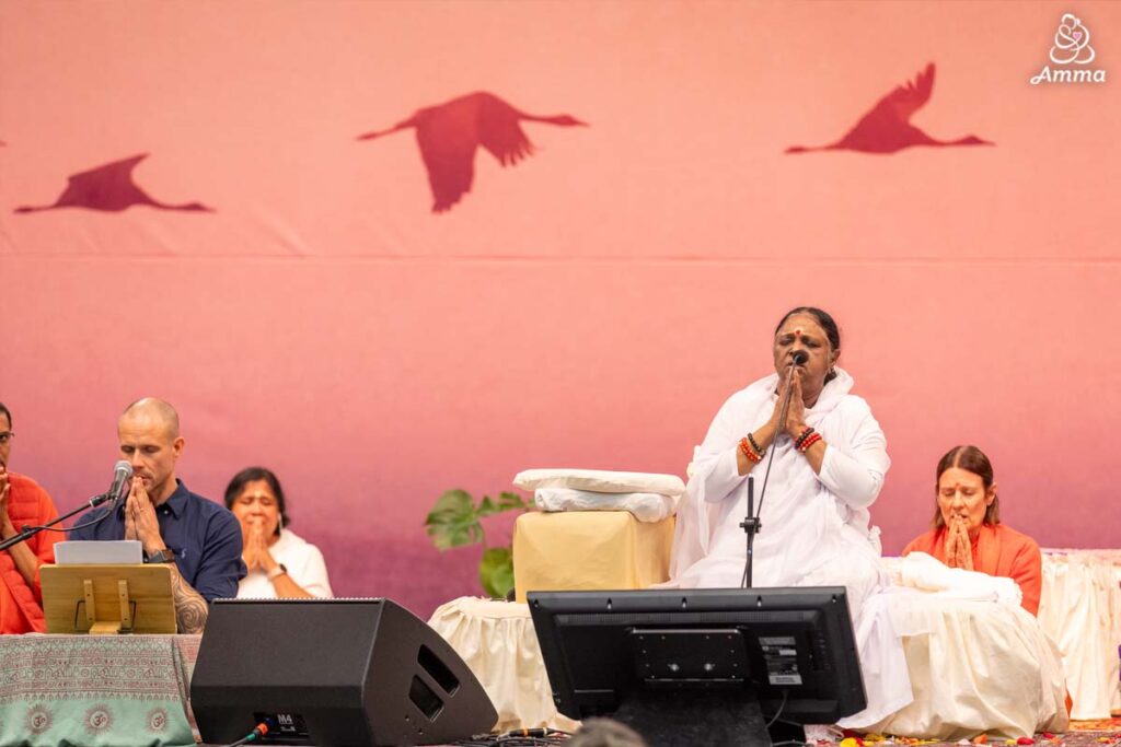 Amma and a devotee at the microphone