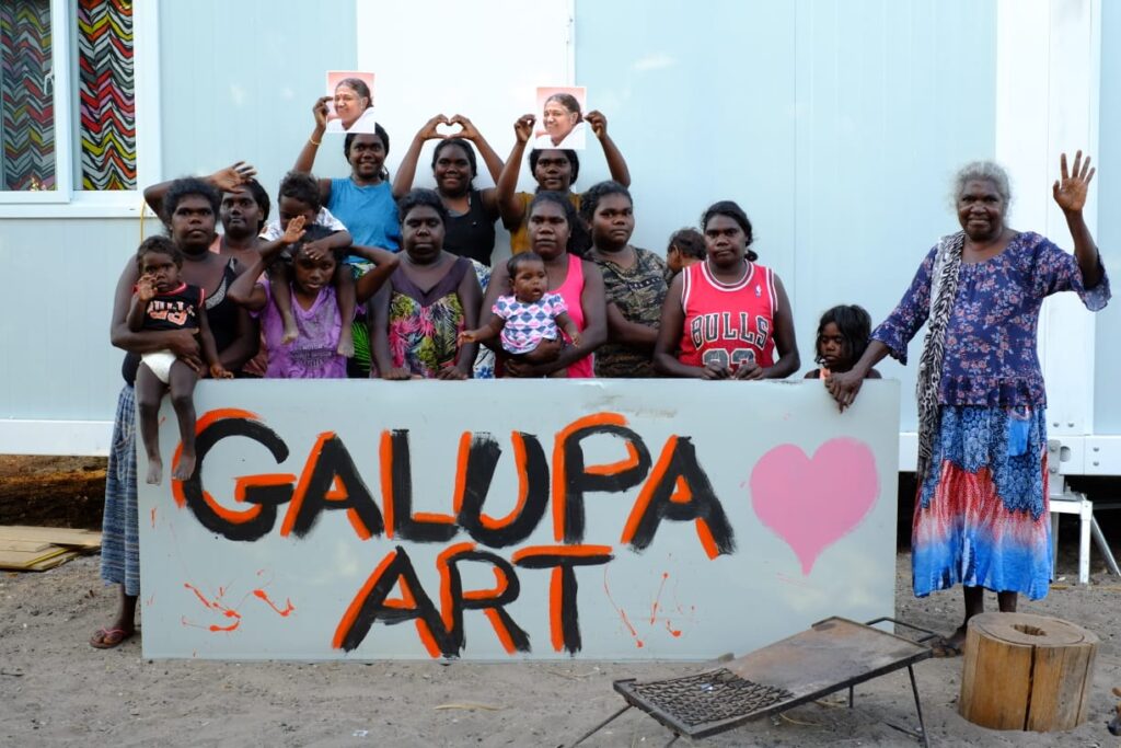 Children and Gayili with a sign saying "GAlupa Art"