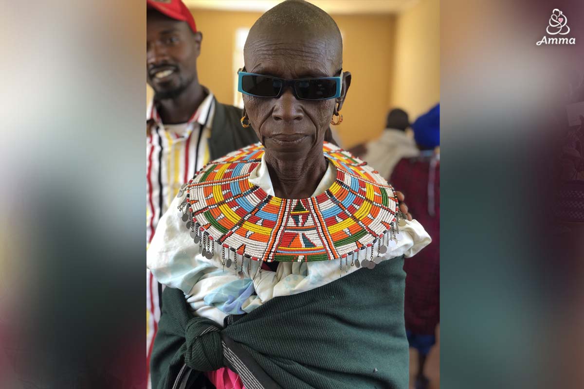 a woman with sunglasses and a colourful, beaded neck adornment