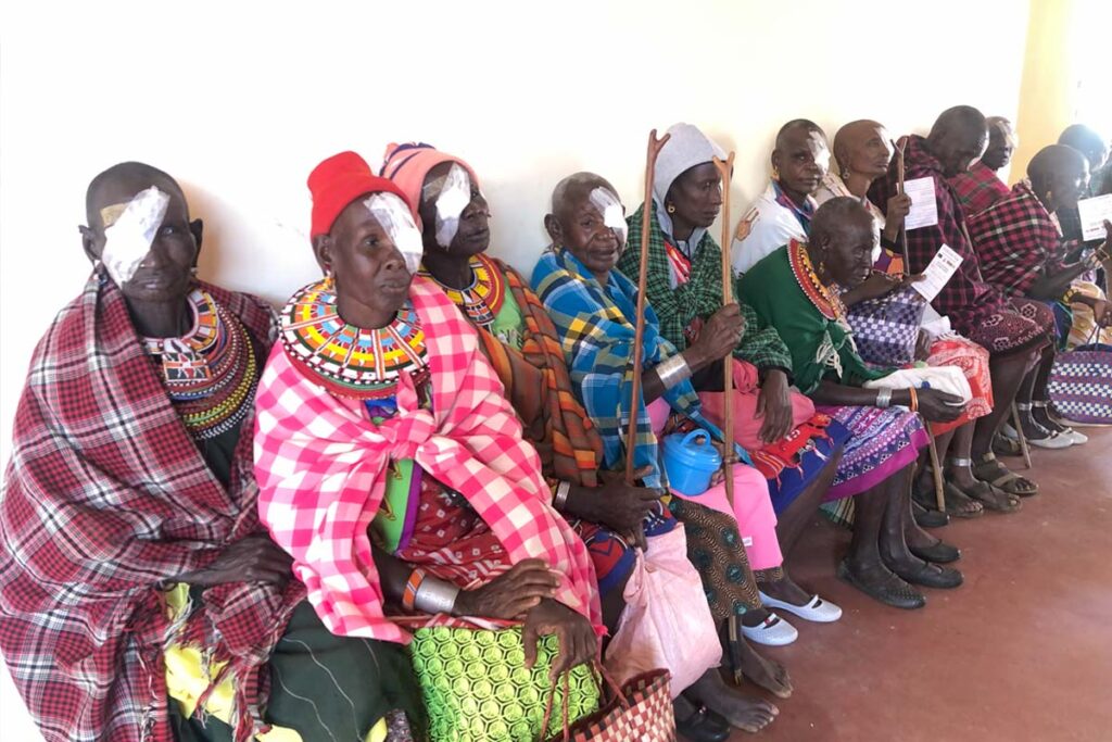 patients sit with their eyes bandaged after surgery