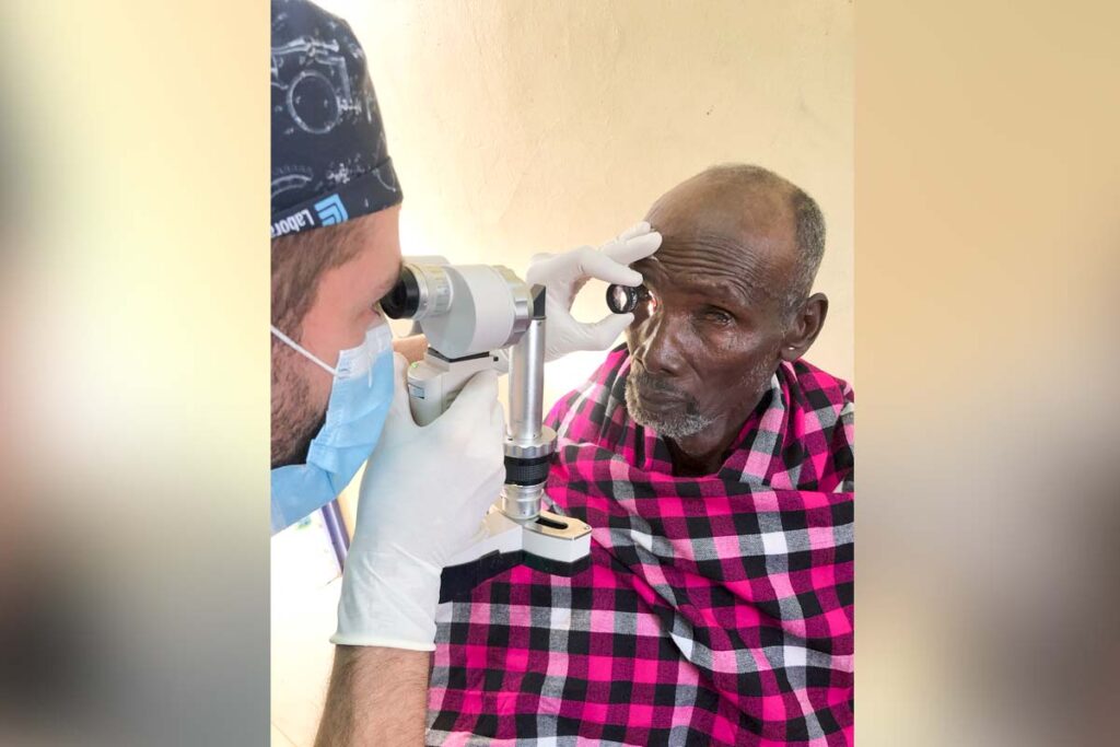 a doctor exams an elderly man's eye