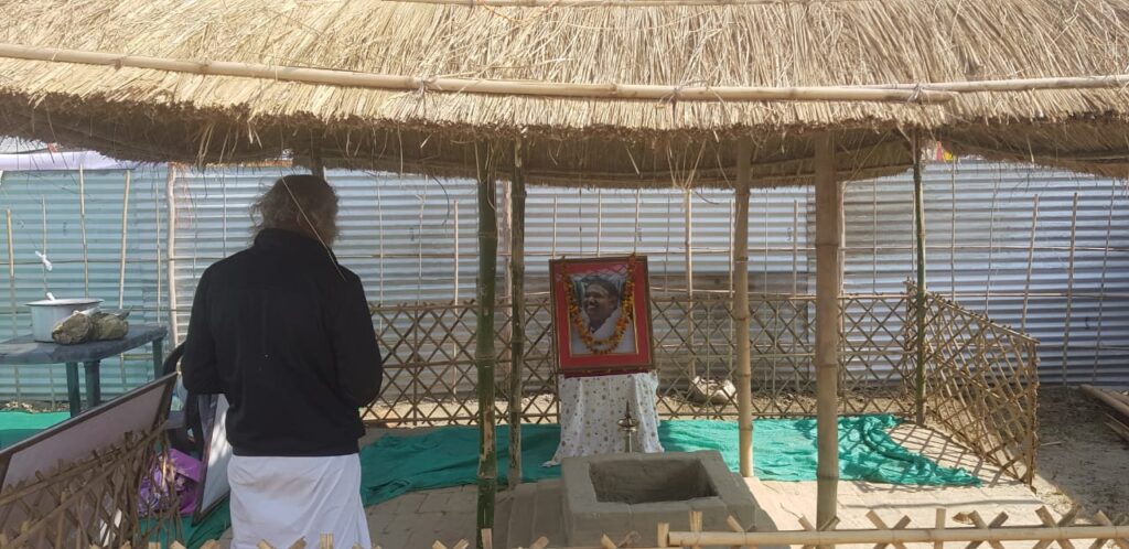 a person looking at a photo of Amma which sits on a small stand inside the tent