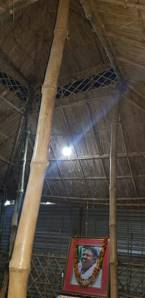 A framed photo of Amma sits inside the tent.