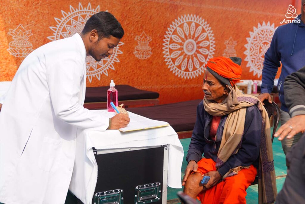 A doctor treats a sadhu with a knee injury