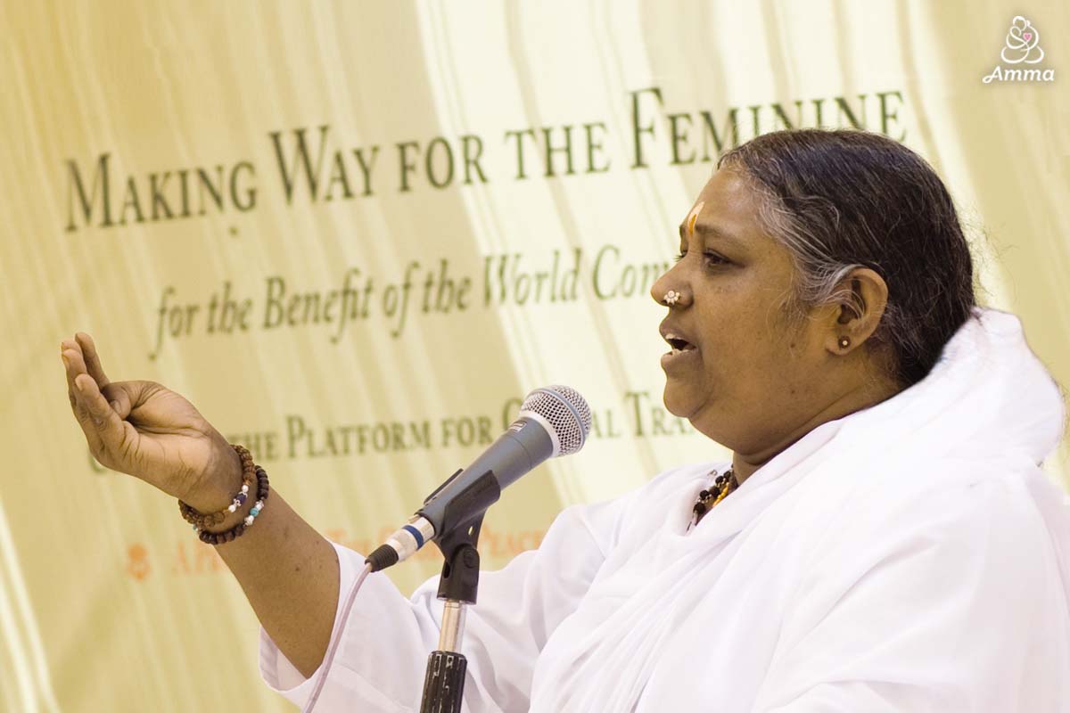 Amma speaks at a microphone