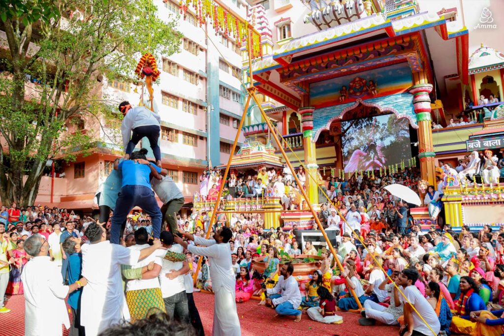 Young men form a human pyramid to break the clay pot