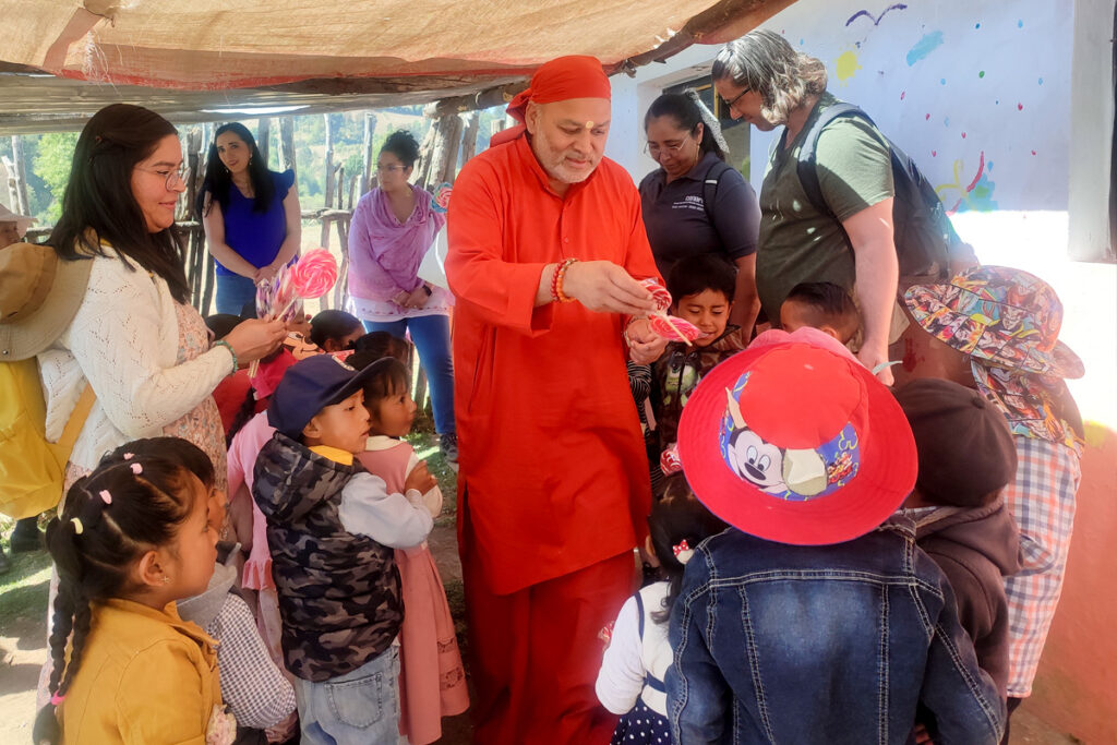Swamiji gives the kids prasad