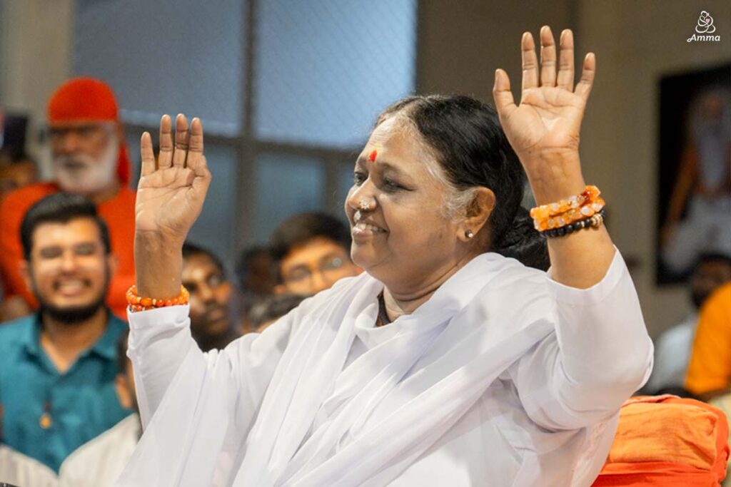 Amma holding up hands and smiling