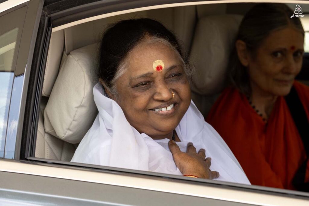 Amma smiles from a car