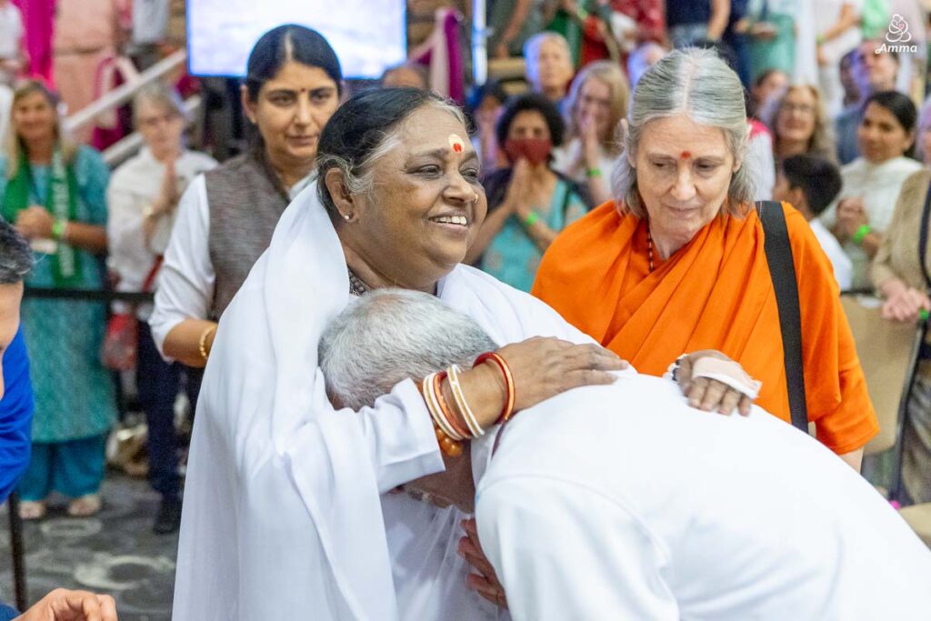 Amma embraces a man on the path to the venue