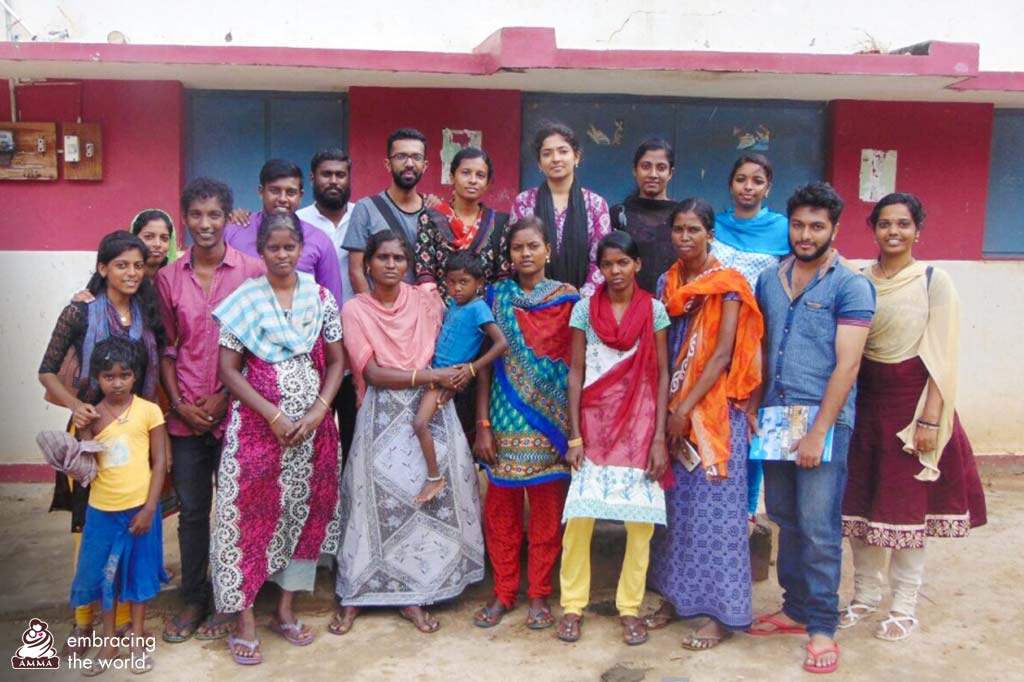 Villagers and students stand together and pose for a photo