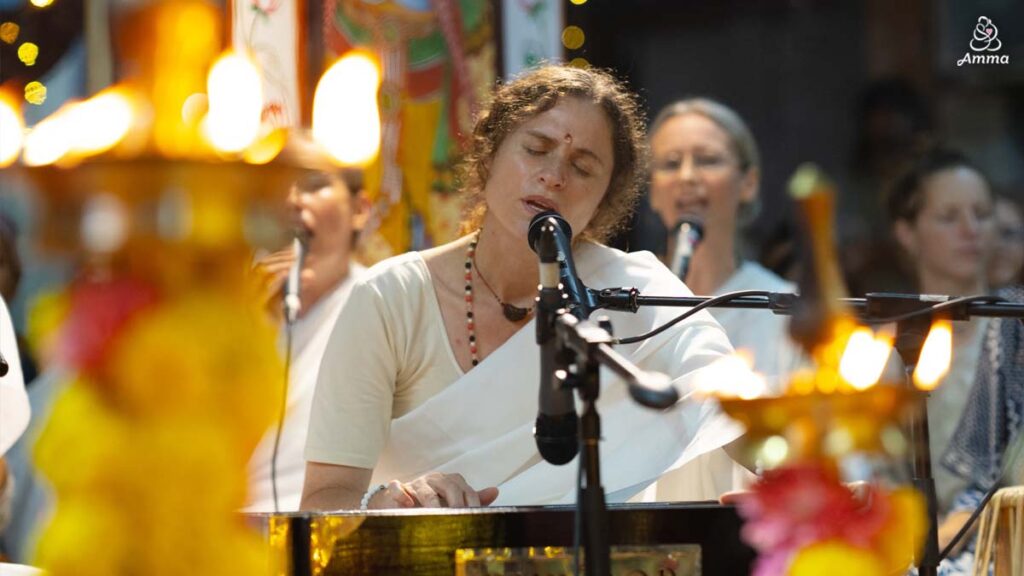 A woman plays a harmonium and sings