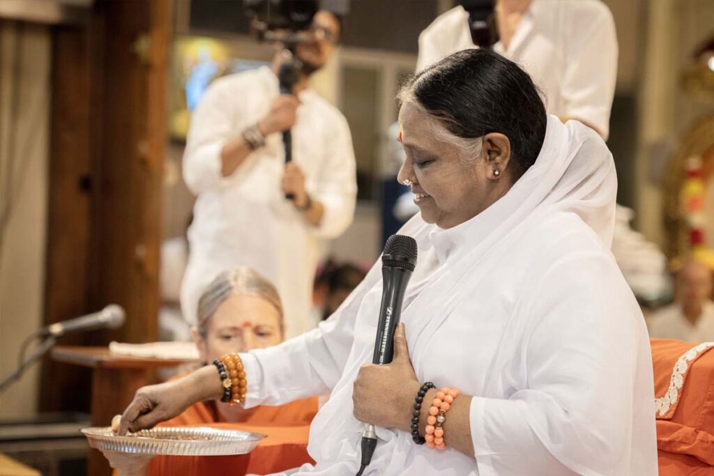 Amma writes on a plate of rice grains