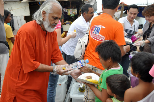 Swami Ramakrishnananda serving a hot meal to typhoon refugees.