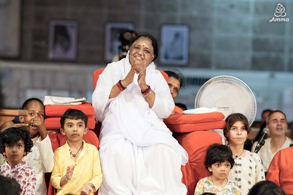 Amma smiles with children around her